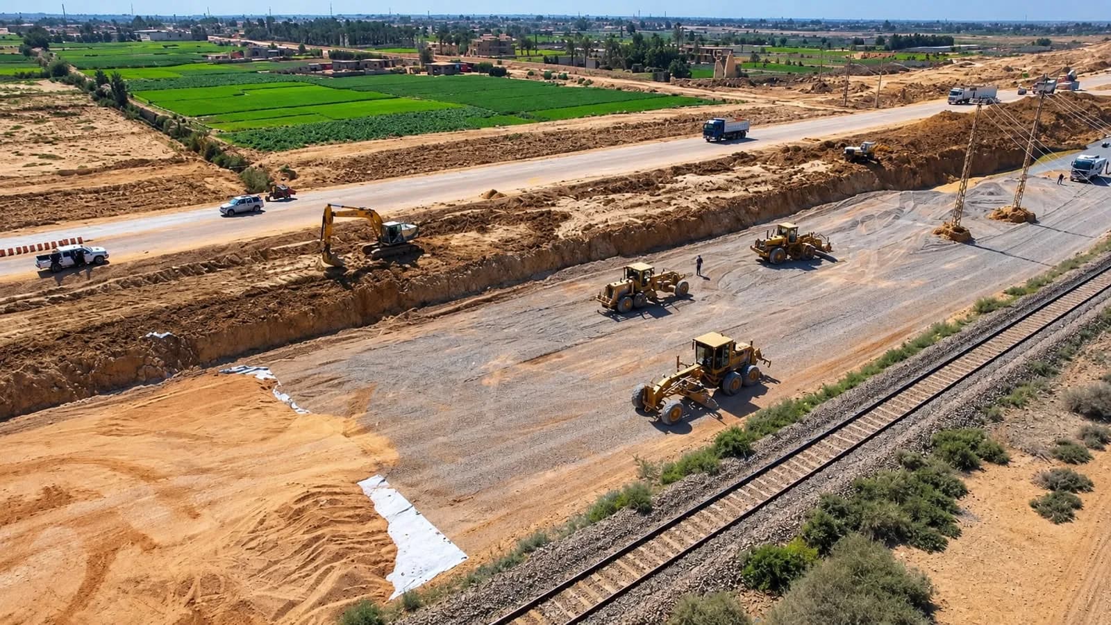 Graders spreading the base course beside the railway